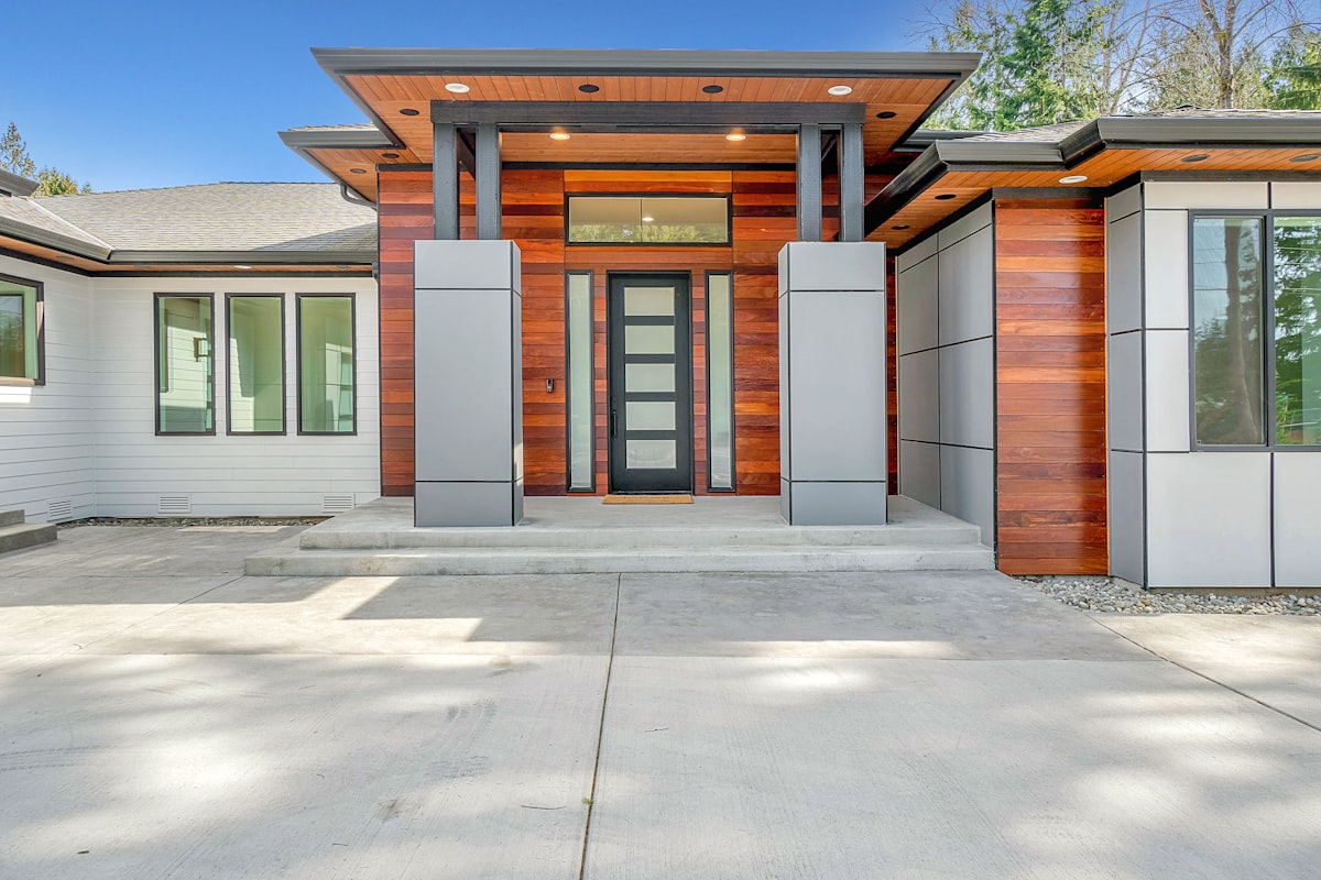 Contemporary home exterior at twilight with warm window lighting